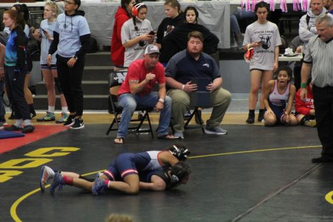 Sophomore Shyene Harris pins her opponent at the regional competition as her teammates watch on in excitement. Coming off of a runner up placement at the prior district competition, the team entered the competition with fierce determination.