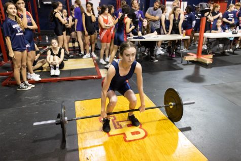 At a meet, senior lifter Mary Bonnett’s teammates watch on as she begins to lift. “I hope that by the end of the season I will be able to bench my bodyweight,” Bonnett said. “I also hope that I make it to regionals and that [the school] can get first at districts.”