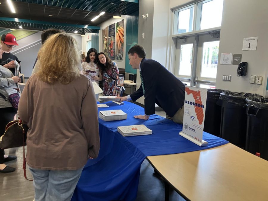 Students and parents stop by the table for the University of Florida, where they could ask questions and pick up pamphlets to learn more about the school and expectations for receiving admission to it. 